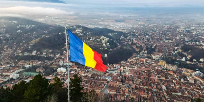 Romania's national flag over a city.