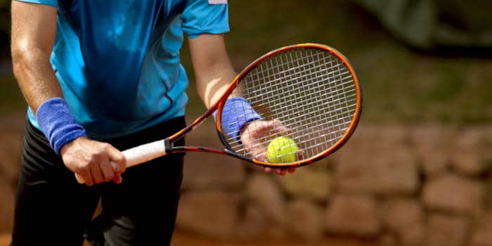 Tennis player serving a ball.