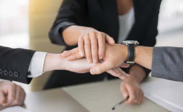 Three people in an office giving high five