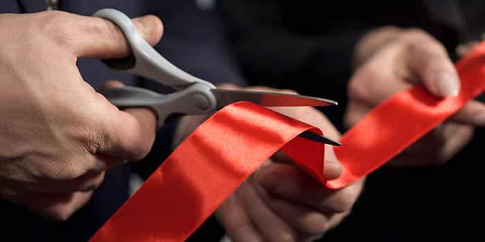 Person cuts a ribbon at an opening ceremony