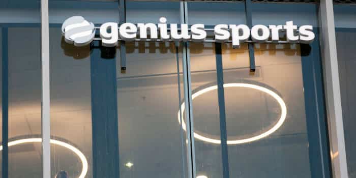 The Genius Sports logo and company name on a building.