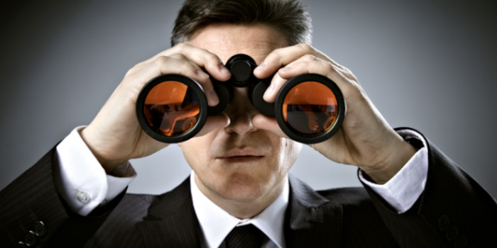 A businessman looking through binoculars