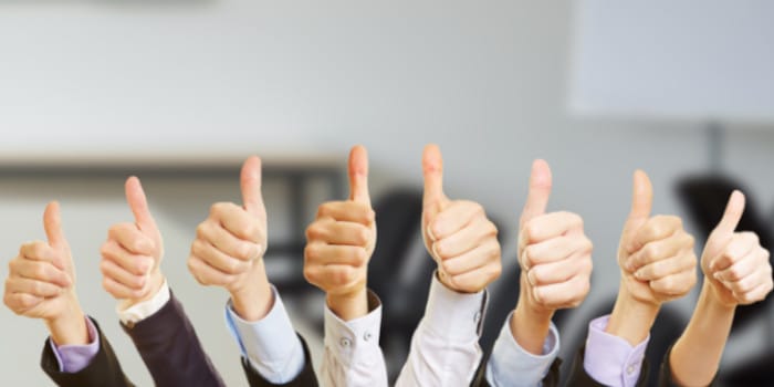 Business team members making thumb up gesture