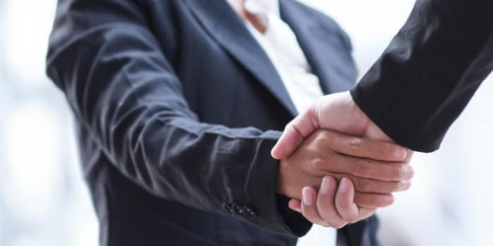 A businessman and businesswoman shaking hands