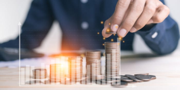 A businessman stacking coins on top of each other, symbol for financial growth