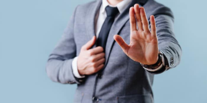 A businessman holding his hand up as a stop gesture