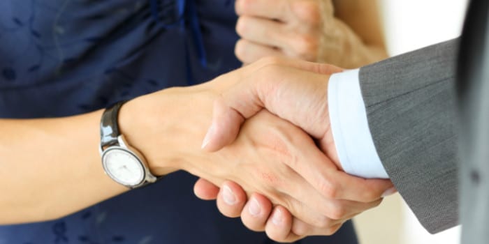 Close up photo of the hand of a businesswoman shaking hand with a businessman