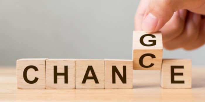 Hand flipping a wooden cube and changing the word chance to change