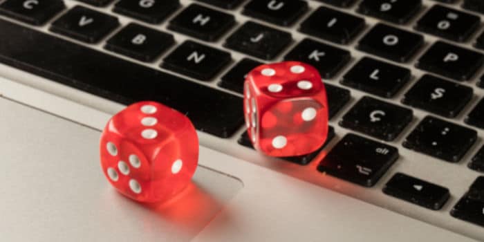 A pair of dice placed on top of a laptop keyboard