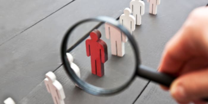 A magnifying glass focused on a red wooden figure