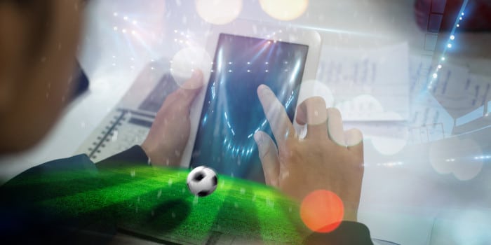 Close up photo of a man placing a sports wager via a smartphone