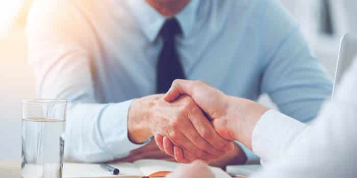 A new worker shakes hands with an interviewer