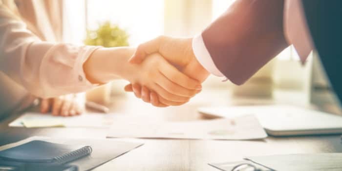 Close up photo of a businessman shaking hand with a businesswoman