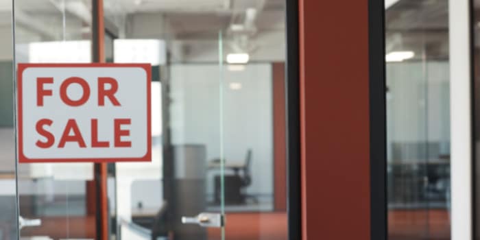 For sale sign on a glass empty office