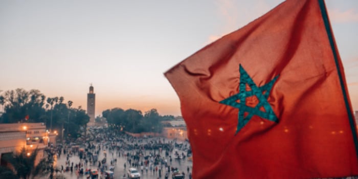 Moroccan flag and a street in Marrakech in background