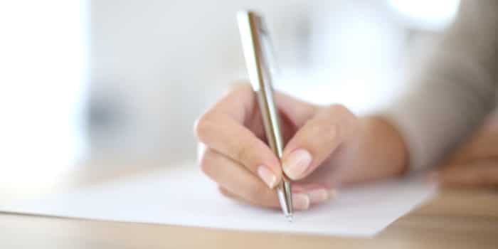 Close up photo of the hand of a woman signing a document