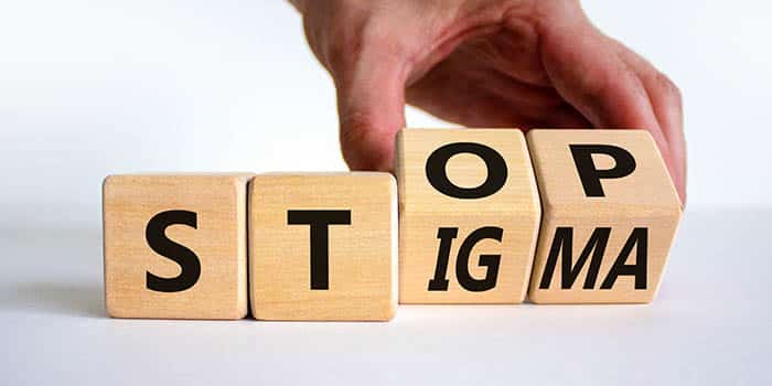 A person arranges cubes in a message, encouraging people to stop stigma