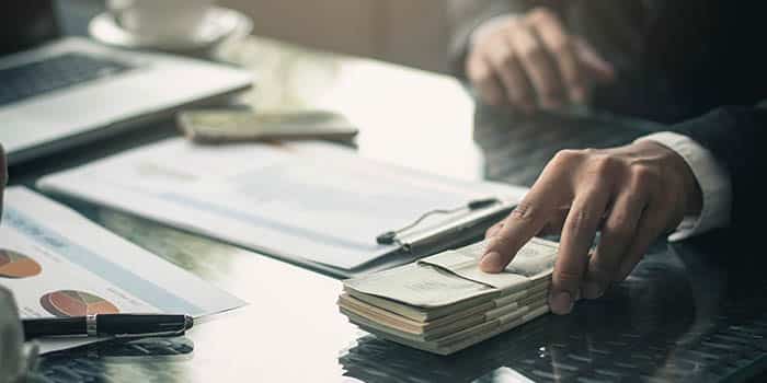 A businessman puts forward a stack of money