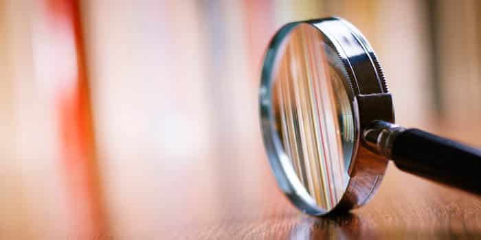 A magnifying glass sitting on a wooden table.