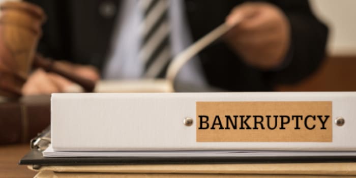 File folder with bankruptcy label on it and a businessman in the background