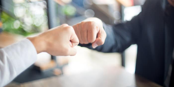 Two businessmen making a fist bump gesture