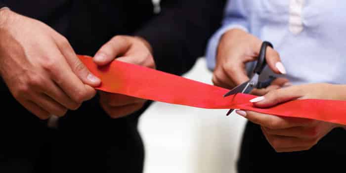 Businesspeople cut ribbon at an opening ceremony