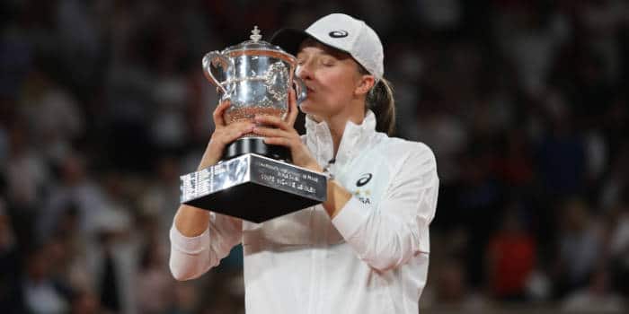 Iga Swiatek tennis player from Poland kissing a trophy.