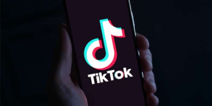 Hand holding smartphone with TikTok app opened