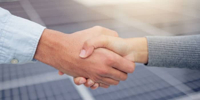 A businessman and businesswoman shake hands