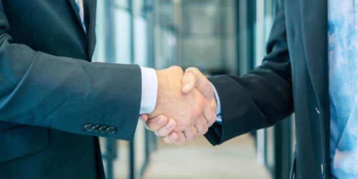 Two businessmen shaking hands, close up photo