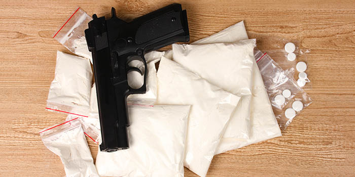 A handgun on top of a pile of drugs