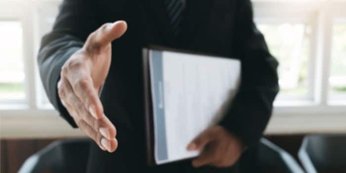 A businessman reaching for a handshake